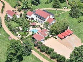 Aerial view of Dolly Parton's estate with pool and red-roofed outbuildings