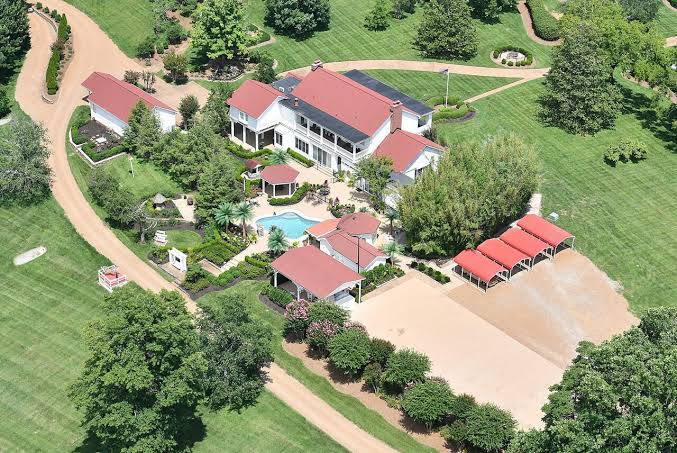 Aerial view of Dolly Parton's estate with pool and red-roofed outbuildings